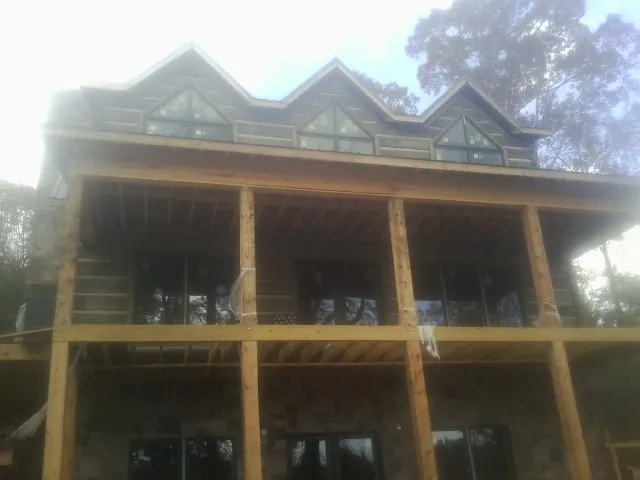 Dormers and porch framing on a large log home under construction — Roof Coating work by our crew in Morgan